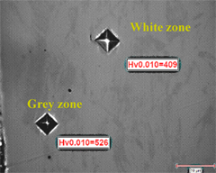 Optical cross-section of stainless steel band AISI301 shaped as a dome and low-load Vickers microhardeness mesurements (Hv) – two phases coexist, one harder than the other